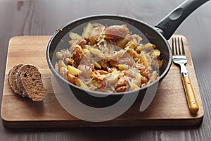 Fried potatoes in a frying pan with rye bread