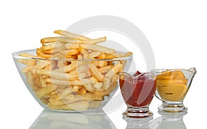 Fried potatoes in large glass bowl, ketchup and mustard isolated on white