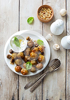 Fried potatoes with mushrooms, pine nuts and cream sauce