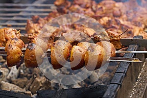 Fried potatoes on skewers, roasted on fire . Delicious food cooked on fire. close up