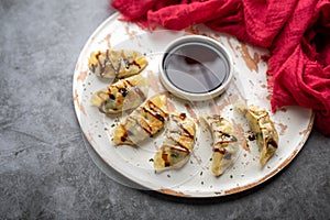 Fried potstickers with balsamic glaze covered in seeds and chives