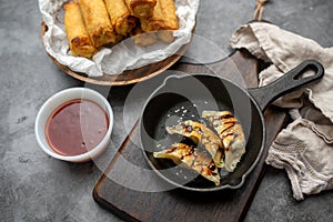 Fried potstickers with balsamic glaze covered in seeds and chives