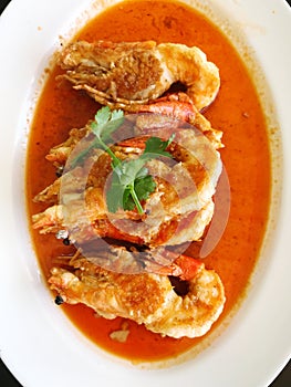 Fried prawns with chilli sauce in white plate.