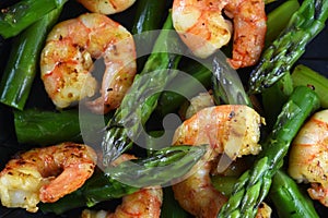 Fried prawns or shrimps with green asparagus, close up as top vi