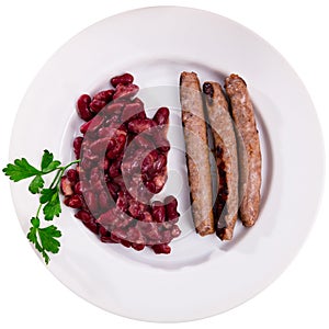 Fried red beans and sausage served on plate and decorated with greenery, traditional dish of Catalonia photo