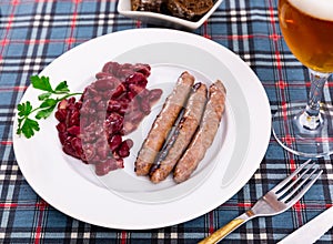 Fried red beans and sausage served on plate and decorated with greenery, traditional dish of Catalonia photo