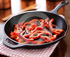Fried red bell peppers cooling in iron skillet