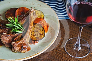 Fried ribs with a glass of red wine on a table in a restaurant close-up