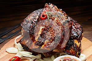 Fried ribs with rosemary, onion, sauce on a wooden round Board.