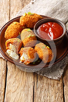 Fried rice balls stuffed with mozzarella suppli al telefono closeup on the plate. Vertical photo