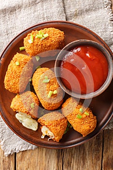 Fried rice balls stuffed with mozzarella suppli al telefono closeup on the plate. Vertical top view photo