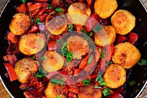 Fried rice balls with vegetables. Homemade fried rice balls with stewed red pepper, onions and tomatoes in a pan