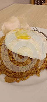 Fried rice with fried egg on a white plate is ready to eat