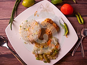 fried rice with fried chicken in a dish top view on wooden background
