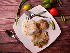 fried rice with fried chicken in a dish top view on wooden background