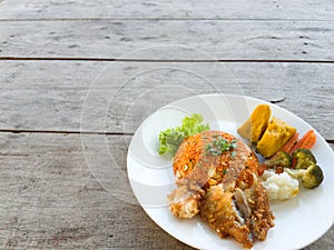 Fried rice, fried chicken  vegetables on a wooden table