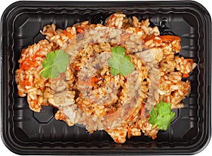 Fried rice with meat in a disposable rectangular plastic black lunch box top view on a white background