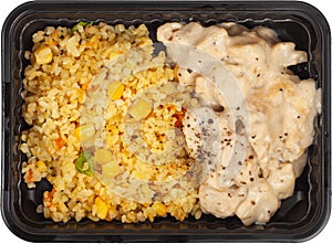 Fried rice with meat in a disposable rectangular plastic black lunch box top view on a white background