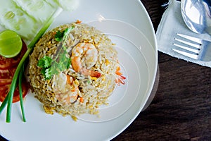 Fried rice with shrimp in a white dish on wood table in thai foo