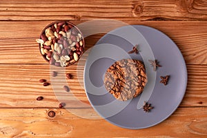 Fried Roasted peanut seed in clay bowl and chocolate cookies on plate. top view