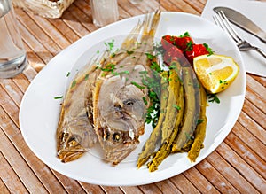 Fried roosterfish with asparagus, tomatoes and lemon