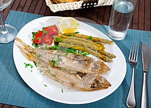 Fried roosterfish with asparagus, tomatoes and lemon