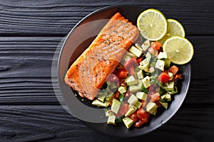 Fried salmon steak with avocado tomato salsa closeup. Horizontal