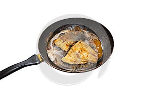 Fried salmon trout fillets in a frying pan in fat, isolated on a white background with a clipping path.