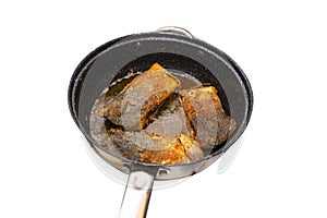 Fried salmon trout fillets in a frying pan in fat, isolated on a white background with a clipping path.