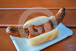 Fried sausage with ketchup on a fresh bun in a cafe in Germany