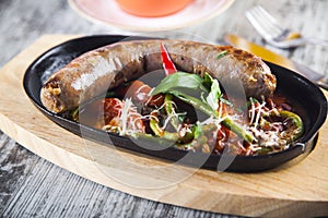 Fried sausage with stewed vegetables in a pan