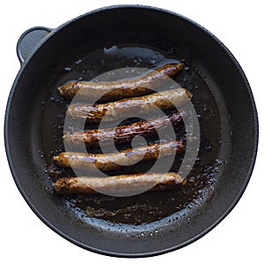 Fried sausages in a cast iron frying pan. close up