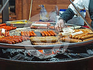 Fried sausages on the grill. German sausage swing grill at city market on holiday