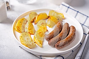 Fried sausages with roasted potato slices