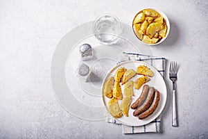 Fried sausages with roasted potato slices