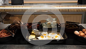 Fried and scrambled eggs and omelette station in a hotel or restaurant setting, catering breakfast