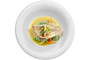 Fried Sea bass fillet with stewed vegetables and orange sauce in a white plate. Isolated on white background. View from above