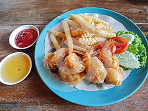 Fried shrimp with french fries and salad