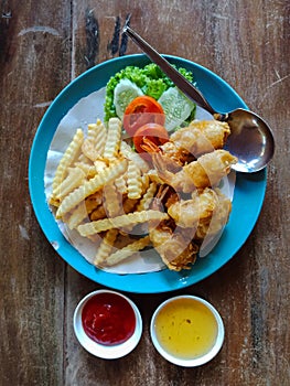 Fried shrimp with french fries and salad, top view