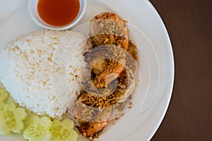 Fried shrimp with garlic and pepper and cooked Thai jasmine rice in white plate