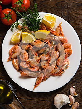 Fried shrimp with lemon in a white plate. top view