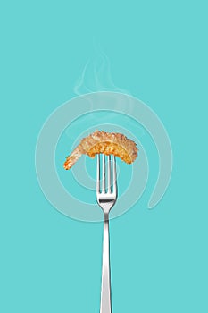 Fried shrimp in pank on a fork isolated on a blue background. Poster for a restaurant. Fried shrimp in pank