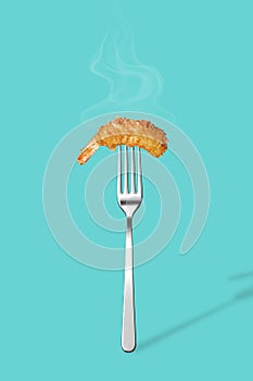 Fried shrimp in pank on a fork isolated on a blue background. Poster for a restaurant. Fried shrimp in pank