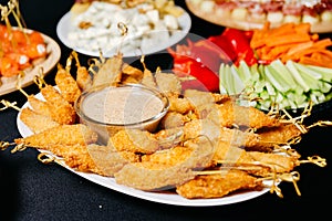Fried shrimps breaded on skewers with nutty sauce