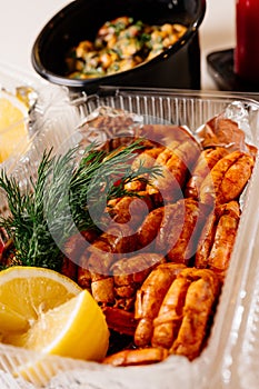 Fried shrimps with dill and lemon on kitchen table