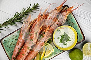 fried shrimps with sauce and lemon wedges on a plate