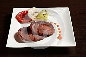 Fried slices of beef sausage with grilled vegetables
