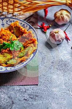 Fried Solanum melongena with Egg in a green dish on the table with garlic, dried chilli