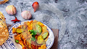 Fried Solanum melongena with Egg in a green dish on the table with garlic, dried chilli