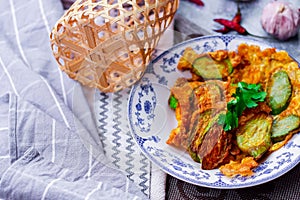 Fried Solanum melongena with Egg in a green dish on the table with garlic, dried chilli